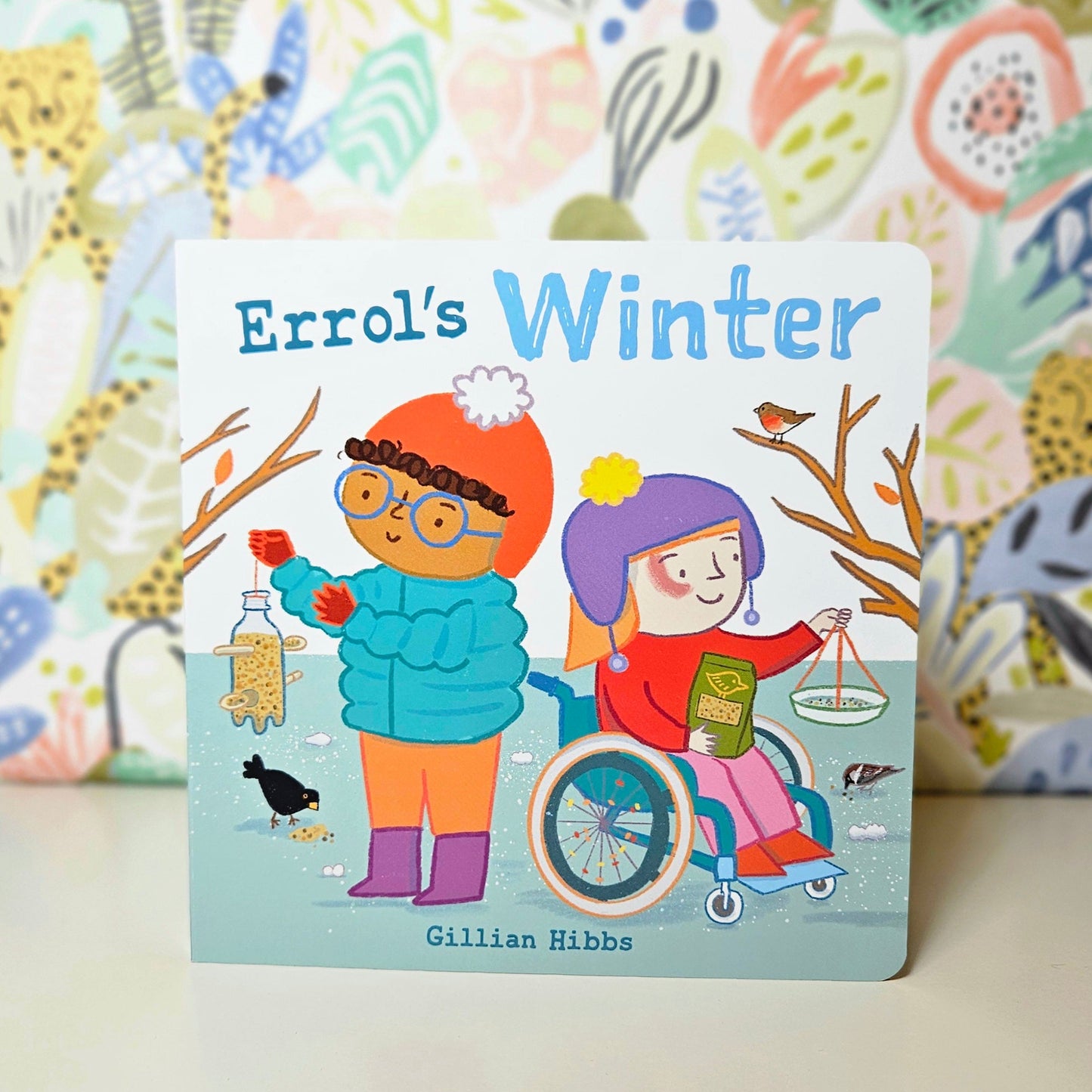 Children's book titled 'Errol's Winter' with colorful illustrations of children feeding birds on a patterned background.
