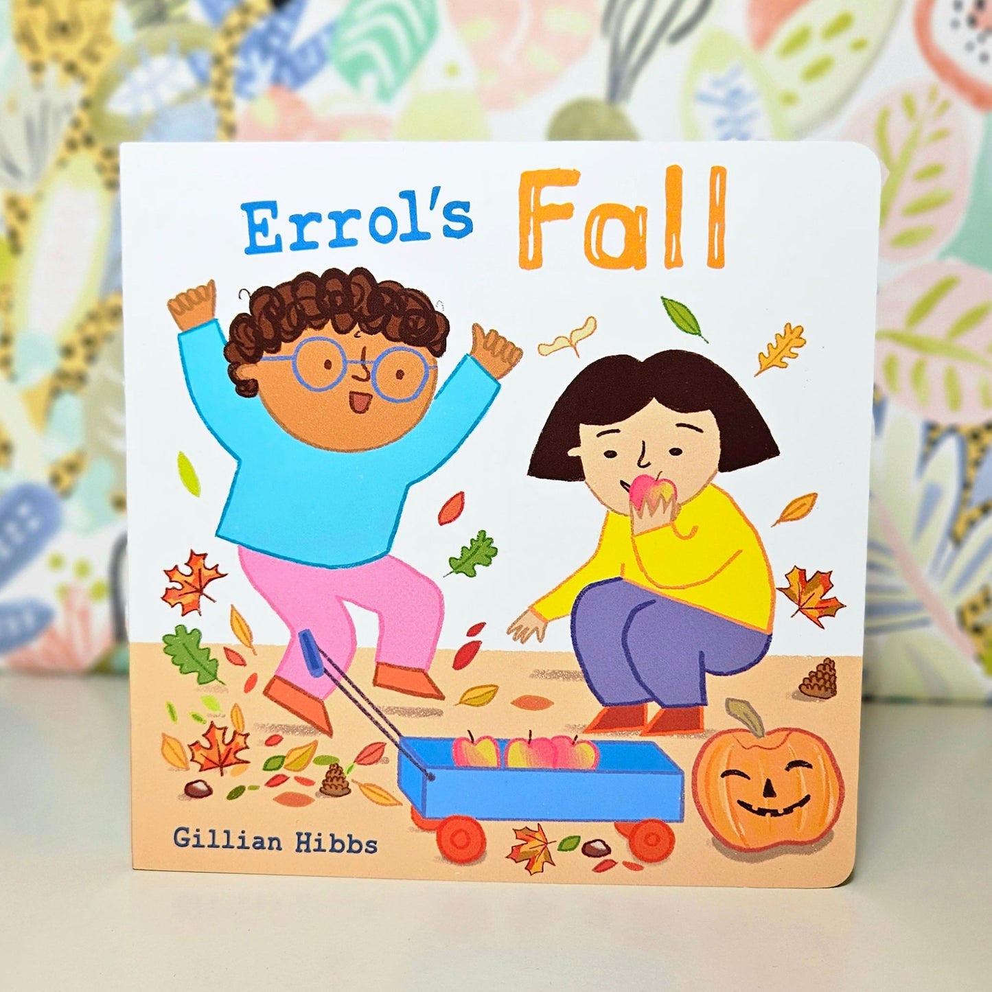 Children's book titled 'Errol's Fall' with illustrations of two children playing with leaves on a colorful background.
