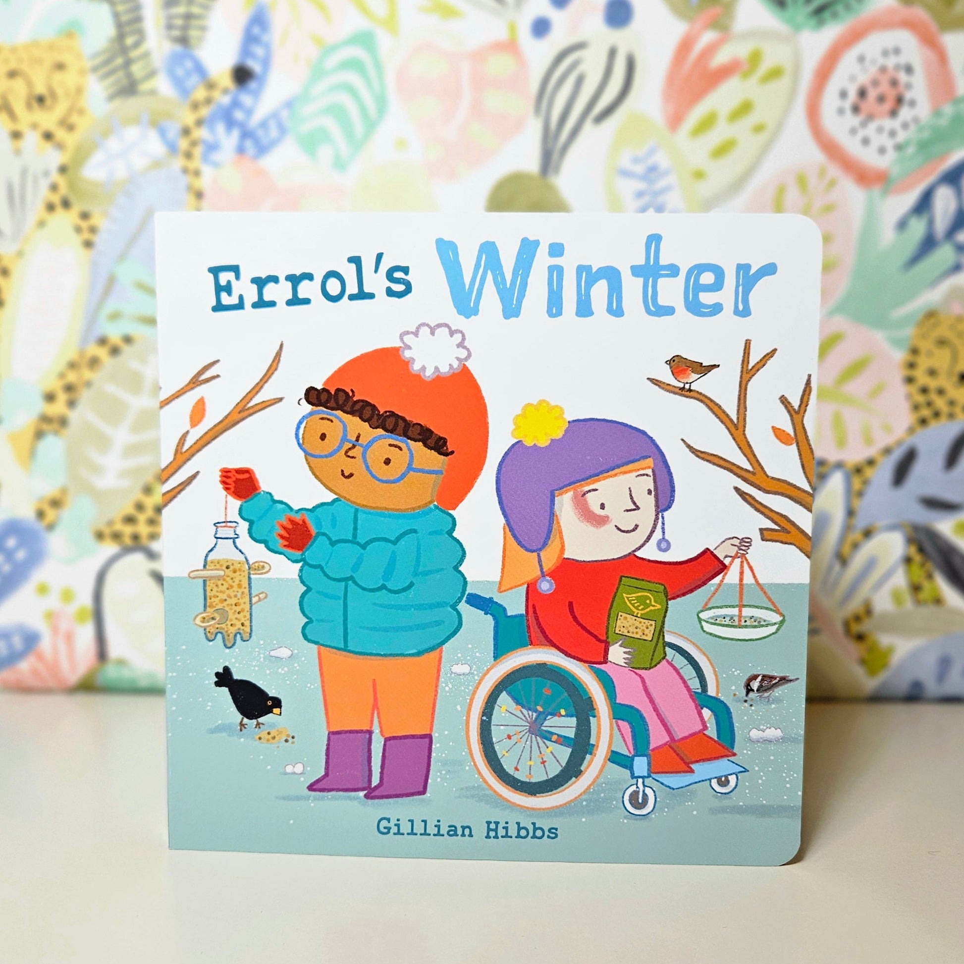 Children's book titled 'Errol's Winter' with colorful illustrations of children feeding birds on a patterned background.